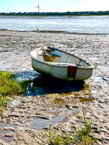 A small boat sitting on top of a sandy beach